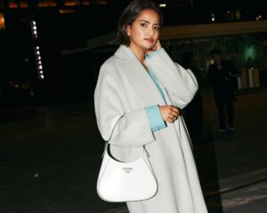 Zeenat Wilkinson with a white Prada Bag and a grey coat outside NZFW